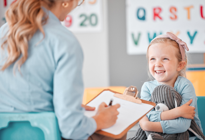 Smiling little girl with therapist
